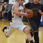 Cook Inlet Academys Hunter Moos drives to the rim against Ninilchiks George Nelson (right) Wednesday at the 2019 Peninsula Conference championship tournament at Cook Inlet Academy in Soldotna. (Photo by Joey Klecka/Peninsula Clarion)