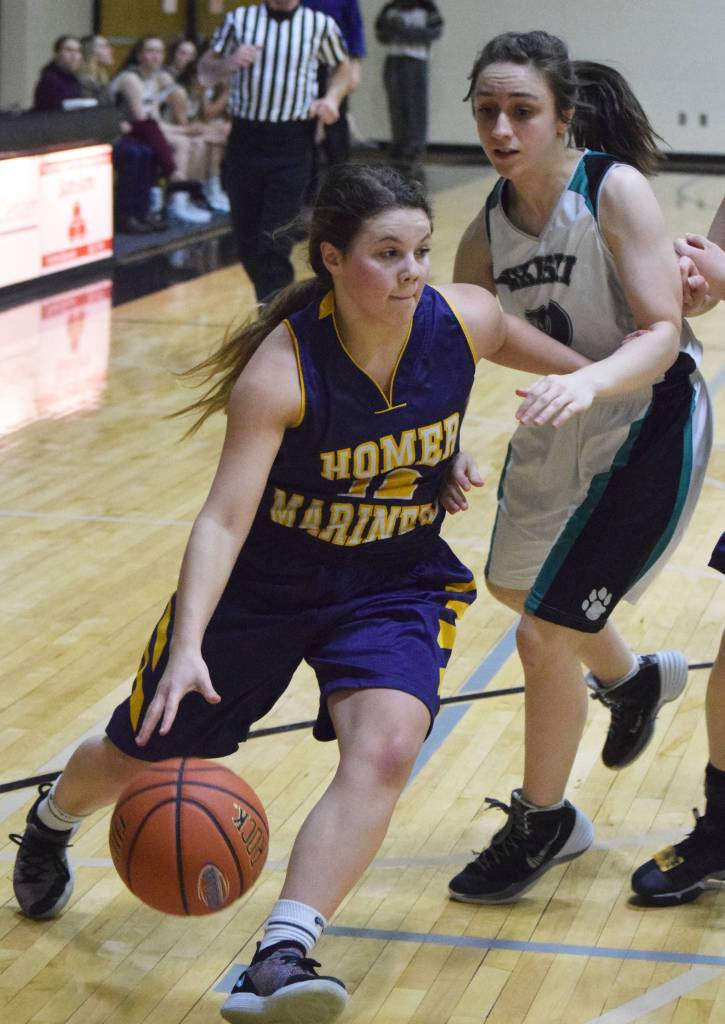 Homers Rylee Doughty (left) dribbles by Nikiskis Carlee Rizzo Friday night in a Southcentral Conference clash at Nikiski High School. (Photo by Joey Klecka/Peninsula Clarion)