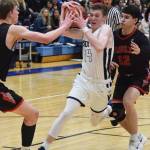 Soldotnas Ray Chumley (14) drives the lane against Wasilla defenders Andrew Devine (left) and Spencer Koval Friday night in the Northern Lights Conference semifinals at Soldotna High School. (Photo by Joey Klecka/Peninsula Clarion)