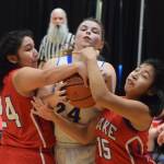 Cook Inlet Academys Anna Cizek (middle) fights for a rebound with Kakes Felicia Ross-Shaquanie (left) and Dionna Jackson, Wednesday at the Class 1A girls basketball state tournament at the Alaska Airlines Center in Anchorage. (Photo by Joey Klecka/Peninsula Clarion)