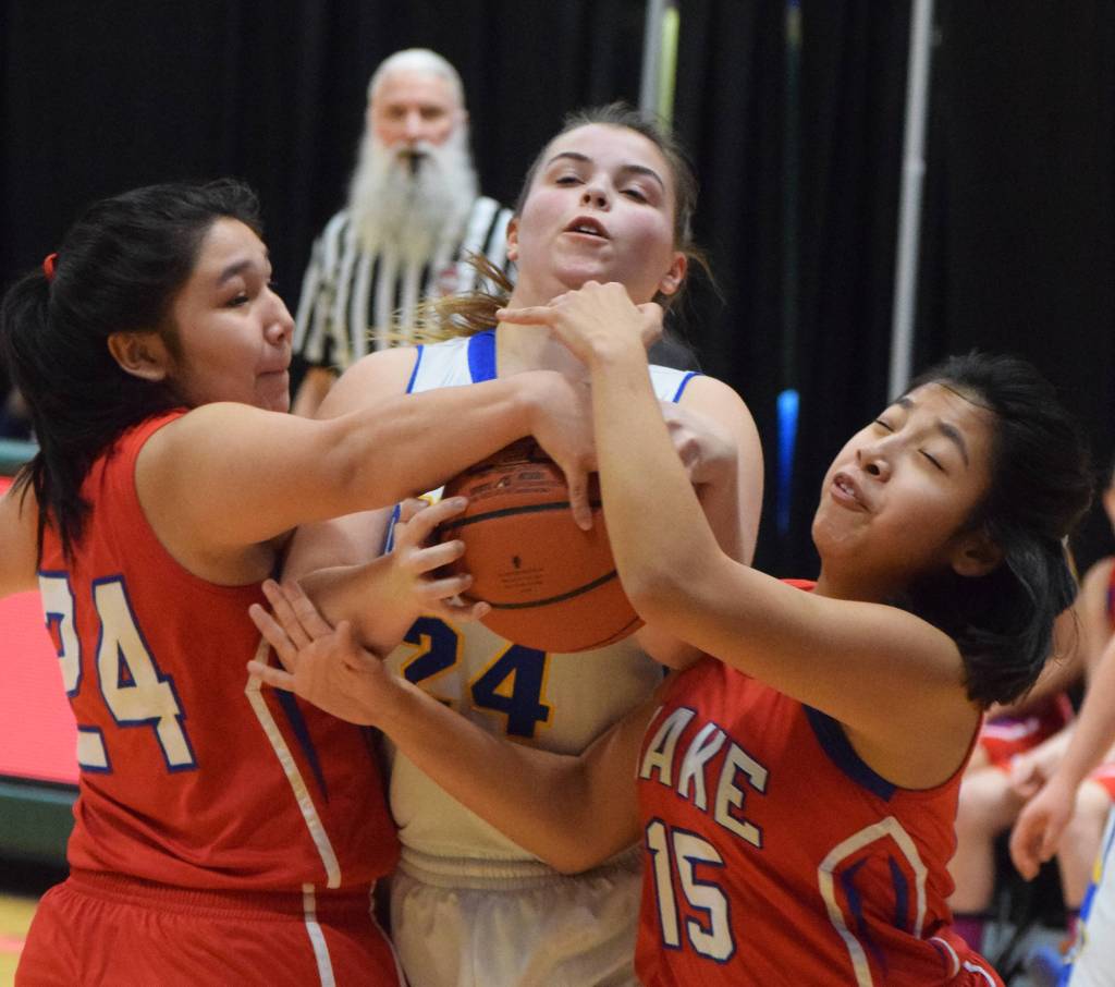 Cook Inlet Academys Anna Cizek (middle) fights for a rebound with Kakes Felicia Ross-Shaquanie (left) and Dionna Jackson, Wednesday at the Class 1A girls basketball state tournament at the Alaska Airlines Center in Anchorage. (Photo by Joey Klecka/Peninsula Clarion)