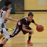 Nikolaevsks Lukah Kalugin looks for space Thursday against Lumen Christi at the Class 1A boys state basketball tournament in Anchorage. (Photo by Joey Klecka/Peninsula Clarion)