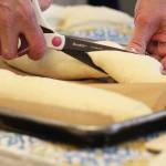 Sharon Roufa of Two Sisters Bakery cuts dough into the shape she wants during a cooking demo on how to bake with sourdough at the Alaska Food Festival on Saturday, March 9, 2019 at Lands End Resort in Homer, Alaska. (Photo by Megan Pacer/Homer News)