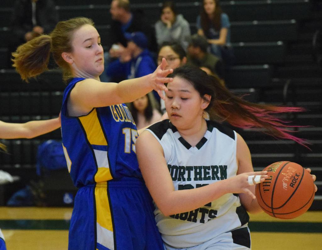 Cook Inlet Academys Adeline Nelson (left) guards Shishmarefs Sonja Ningeulook Friday at the Class 1A state tournament at the Alaska Airlines Center in Anchorage. (Photo by Joey Klecka/Peninsula Clarion)
