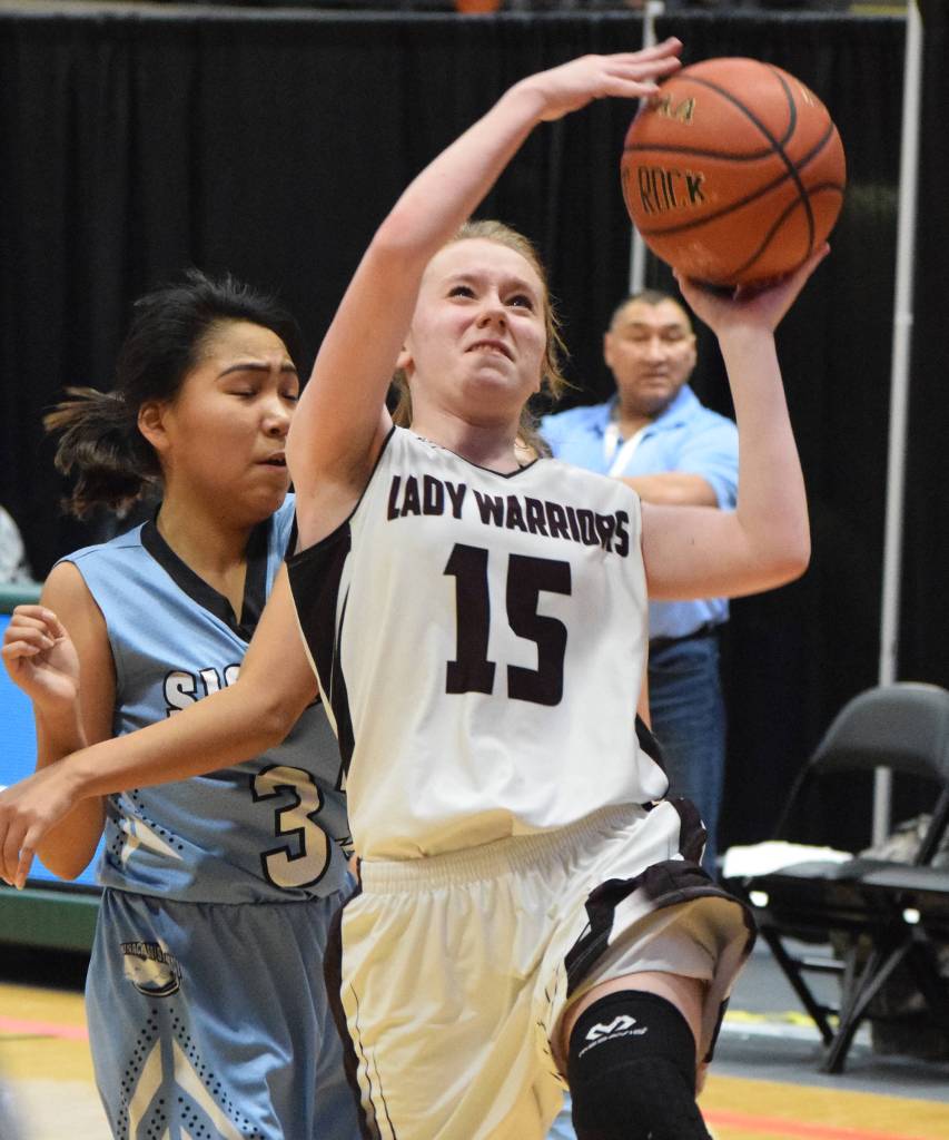 Nikolaevsks Markiana Yakunin (15) drives to the rim over Bucklands Charlene Brown Friday at the Class 1A state tournament at the Alaska Airlines Center in Anchorage. (Photo by Joey Klecka/Peninsula Clarion)
