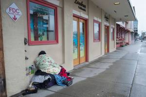 A homeless person sleeps on the sidewalk along South Franklin Street on Friday, March 15, 2019. (Michael Penn | Juneau Empire)
