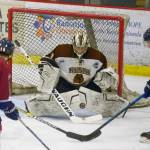 Kenai River Brown Bears goaltender Gavin Enright tracks the puck in front of Bears defenseman Ryan Reid and Fairbanks Ice Dogs forwards Parker Brown and Jonathan Sorenson on Friday at the Soldotna Regional Sports Complex. (Photo by Jeff Helminiak/Peninsula Clarion)