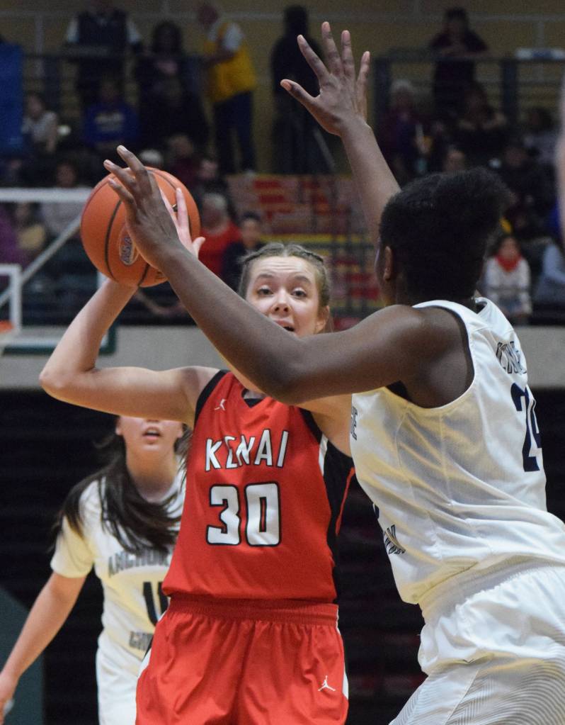 Kenais Brooke Satathite (30) looks for an open teammate with ACS defender Jordan Todd in her face Friday, March 22, 2019, at the Class 3A girls state tournament at the Alaska Airlines Center in Anchorage. (Photo by Joey Klecka/Peninsula Clarion)