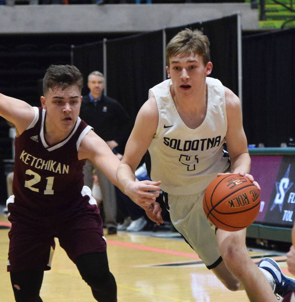 Soldotnas Tyler Morrison evades the grasp of Ketchikans Kristian Phil (left) Friday, March 22, 2019, at the Class 4A boys state tournament at the Alaska Airlines Center in Anchorage. (Photo by Joey Klecka/Peninsula Clarion)