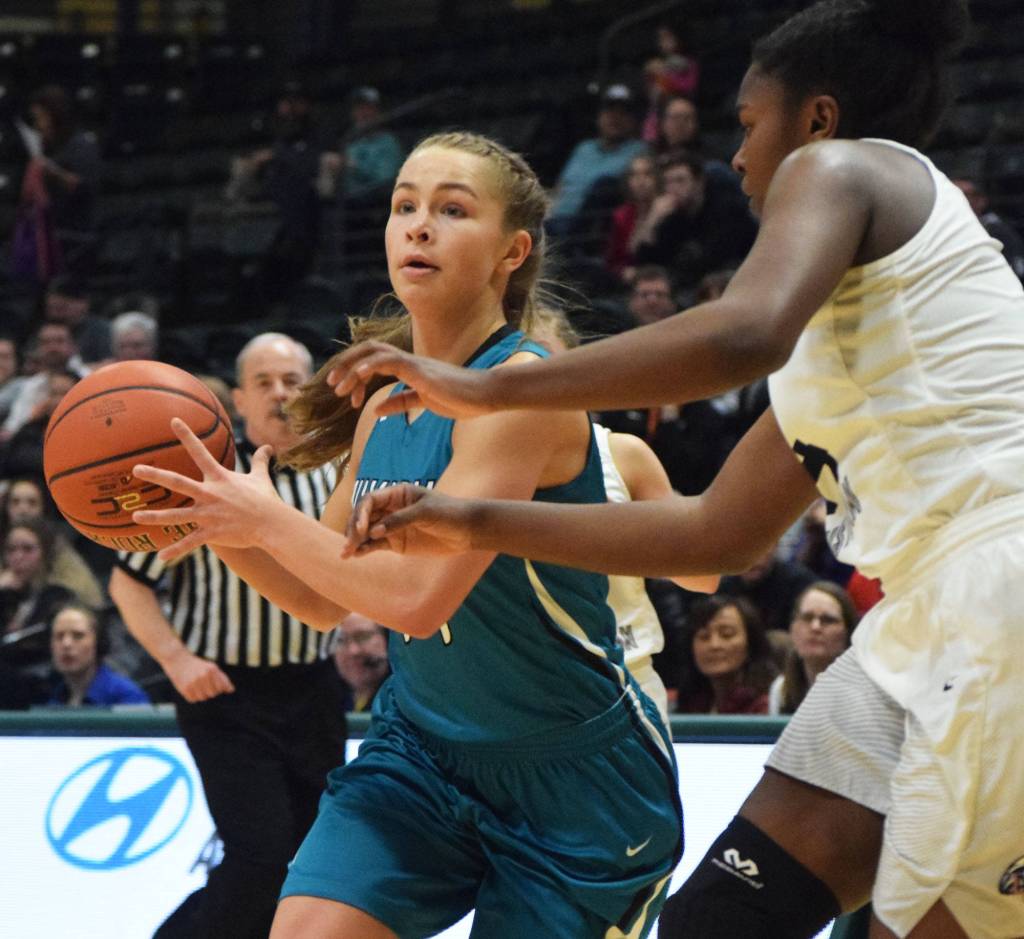 Nikiskis Kaitlyn Johnson (left) works her way around ACSs Jordan Todd on Saturday in the Class 3A girls state basketball championship at the Alaska Airlines Center in Anchorage. (Photo by Joey Klecka/Peninsula Clarion)