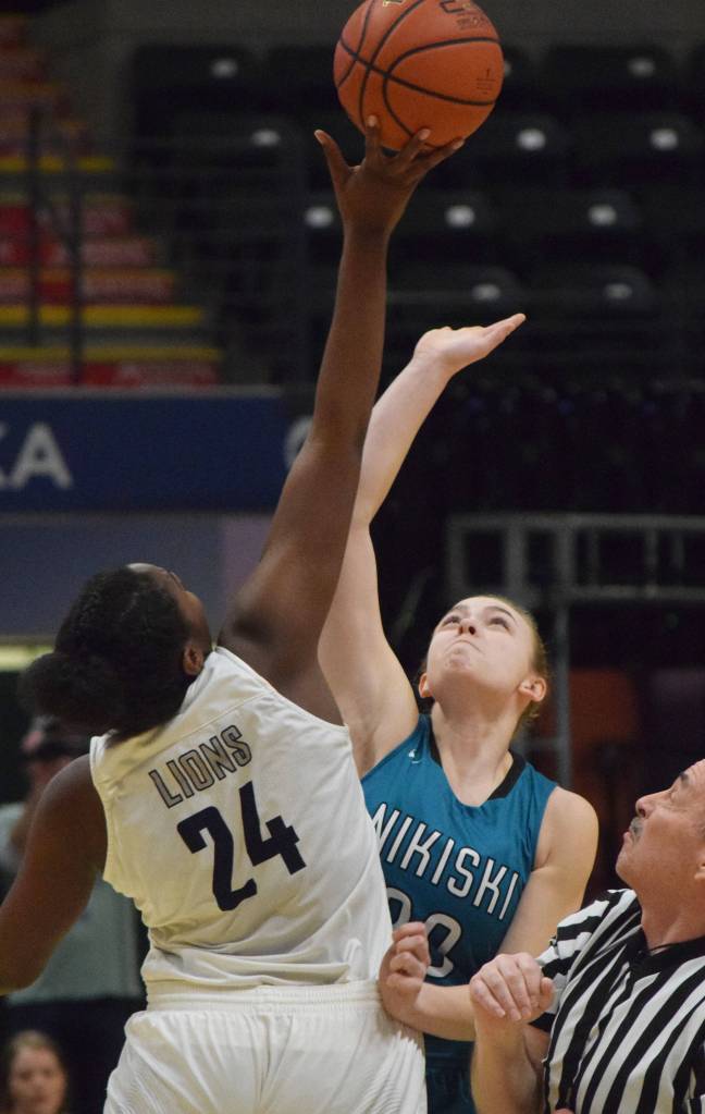 Nikiskis Bethany Carstens (right) and ACSs Jordan Todd tip off to begin Saturdays Class 3A girls state basketball championship at the Alaska Airlines Center in Anchorage. (Photo by Joey Klecka/Peninsula Clarion)