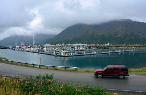 In this Sept. 23, 2013, file photo, a driver passes a small boat harbor in King Cove, Alaska. A federal court judge says Trump administration plans for a road through a national wildlife refuge in Alaska violates federal law. The order Friday, March 29, 2019 by U.S. District Court Judge Sharon Gleason halts plans for a road through the Izembek National Wildlife Refuge near the tip of the Alaska Peninsula. The refuge encompasses internationally recognized habitat for migrating waterfowl. (James Brooks/Kodiak Daily Mirror via AP, File)