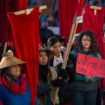 Native women hold up red dresses to symbolize missing and murdered indigenous women during the Womens March on Juneau in front of the Alaska State Capitol on Saturday, Jan. 19, 2019. (Michael Penn | Juneau Empire)