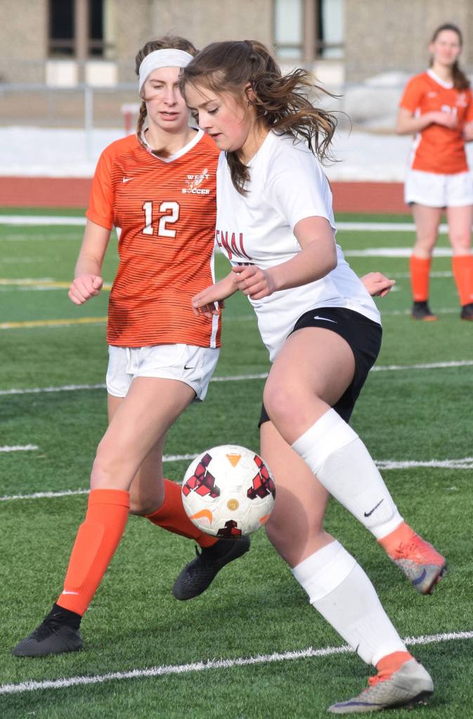 Kenais Rileigh Pace (right) manuevers the ball around West defender Jamey Roy (12) Thursday, April 4, 2019, in a nonconference game at Kenai Central High School. (Photo by Joey Klecka/Peninsula Clarion)