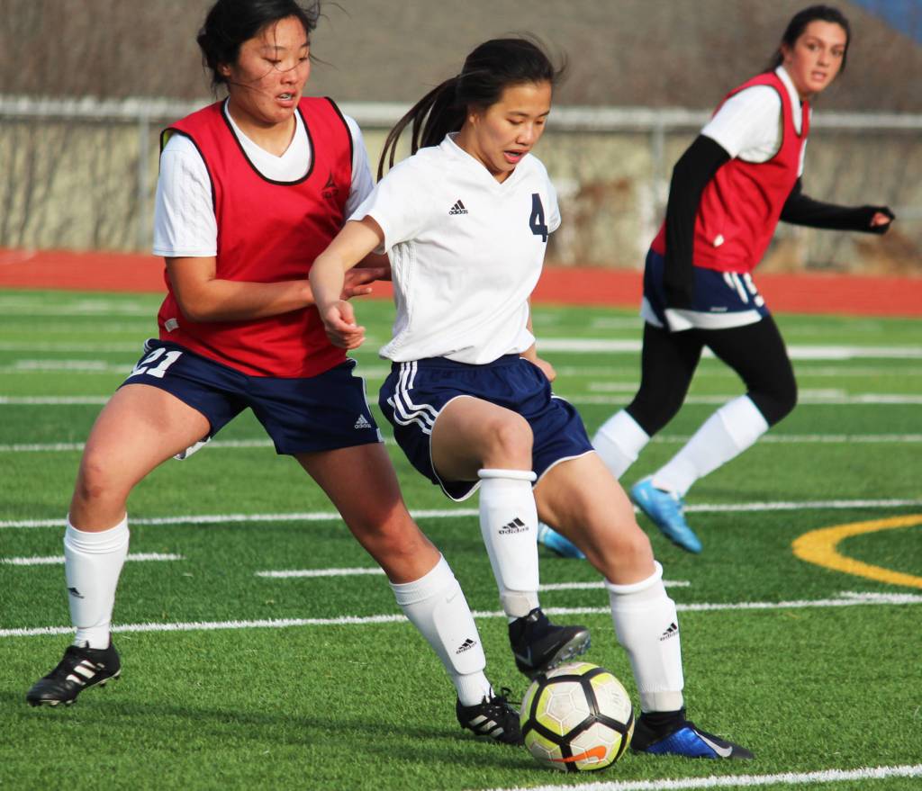 Soldotnas Meijan Leaf fights to keep possession of the ball under pressure from Homers Alyssum Veldstra during a Tuesday game in Homer. The teams tied the game 3-3. (Photo by Megan Pacer/Homer News)