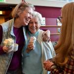 In this March 8, 2019 photo, Margie Beedle, left, hugs her mother, Sally Thibodeau, as they chat with Alaska Pioneer Home employee Laura Minne during the homes weekly ice cream social. (Michael Penn | Juneau Empire File)