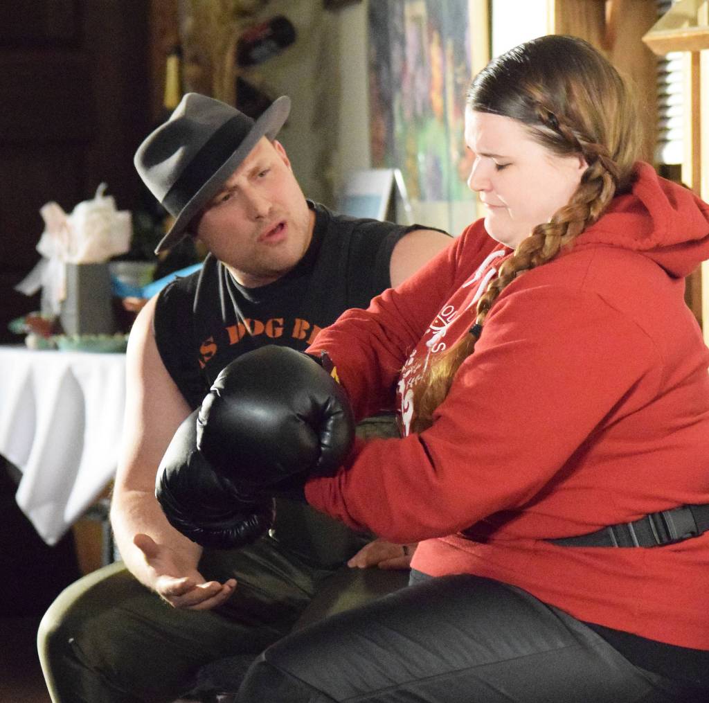 Tyler Payment (left) acts out a scene with Kate Schwarzer during Triumvirants dinner theatre production of Sockeye Balboa Friday, April 5, 2019, at Mykels Restaurant in Soldotna. (Photo by Joey Klecka/Peninsula Clarion)