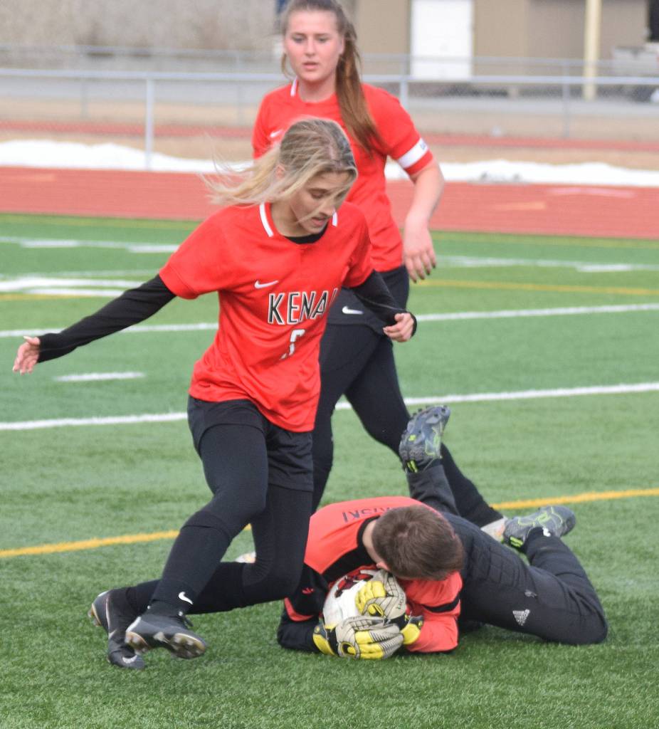 Nikiski goalkeeper Abby Bystedt (on ground) saves a shot taken by Kenais Karley Harden Thursday in a Peninsula Conference clash at Kenai Central High School. (Photo by Joey Klecka/Peninsula Clarion)