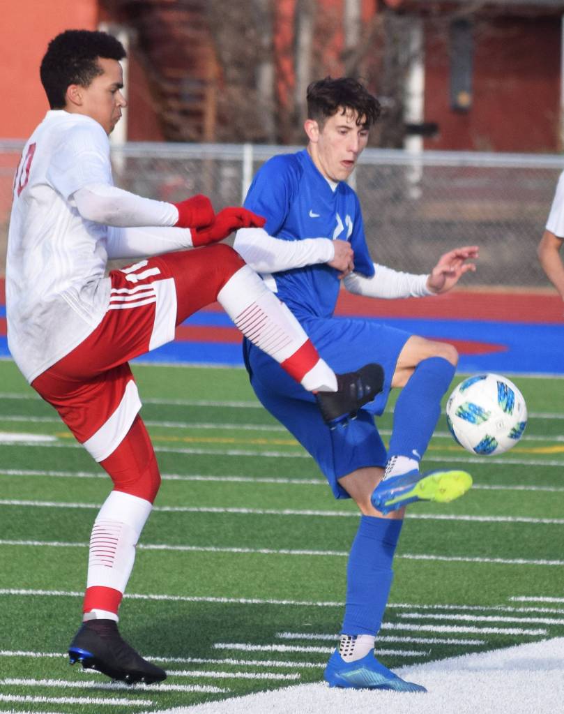 Soldotnas Josh Heiber (right) battles for the ball with North Poles Daniel Crutcher, Friday, April 12, 2019, in a nonconference game at Soldotna High School. (Photo by Joey Klecka/Peninsula Clarion)