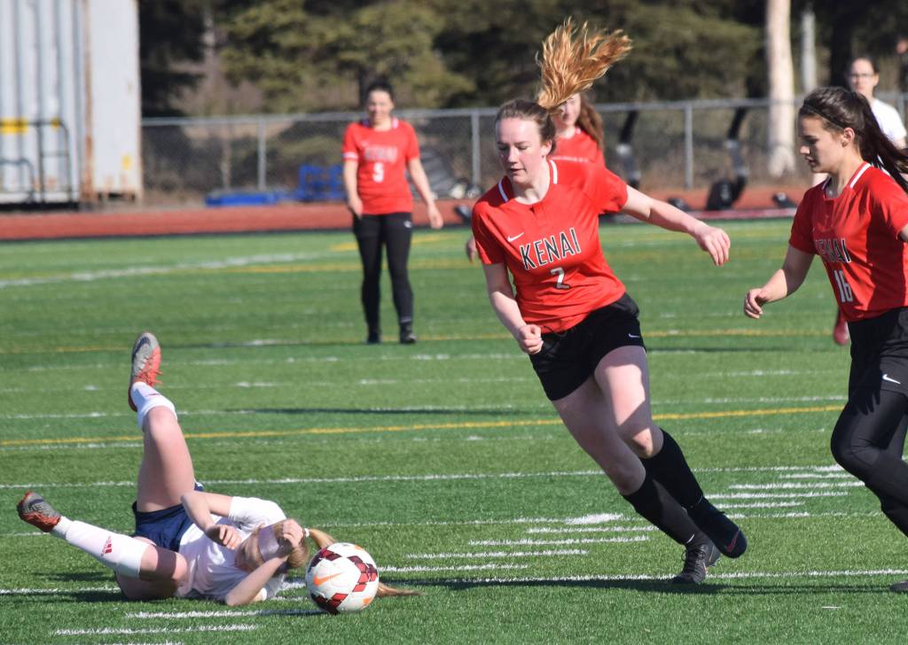 Kenais Bethany Morris (right) evades a falling North Pole player Saturday, April 13, 2019, in a nonconference game at Kenai Central High School. (Photo by Joey Klecka/Peninsula Clarion)