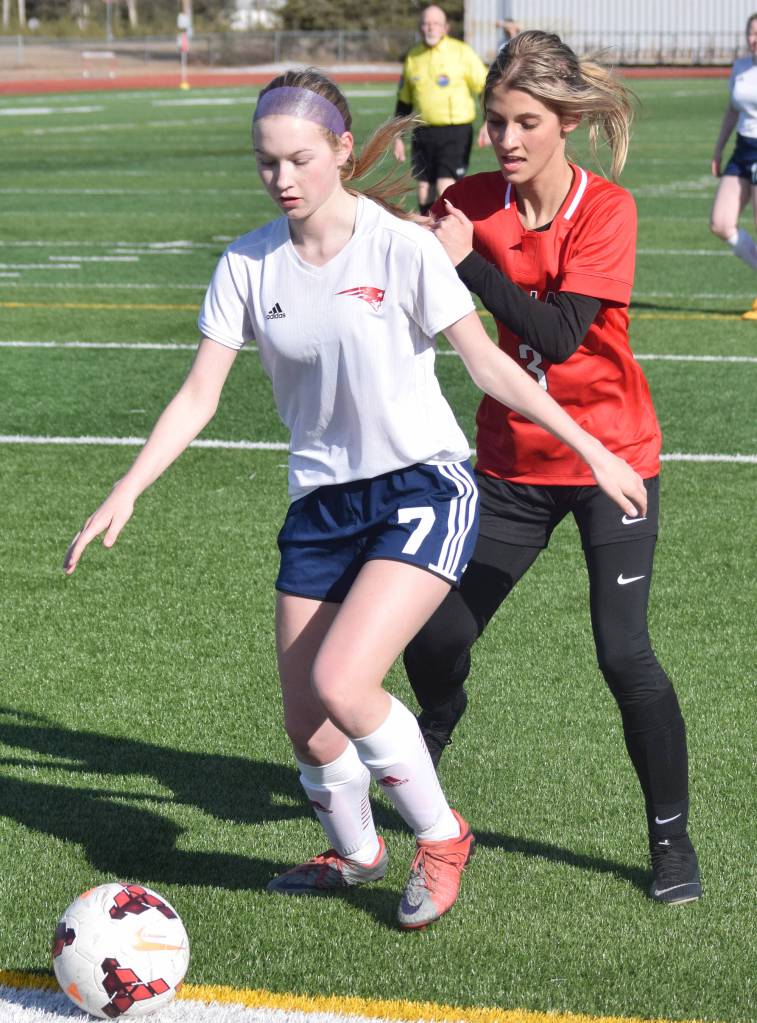 Kenais Karley Harden (behind) battles for the ball with North Poles Chalayna Culler Saturday, April 13, 2019, in a nonconference game at Kenai Central High School. (Photo by Joey Klecka/Peninsula Clarion)