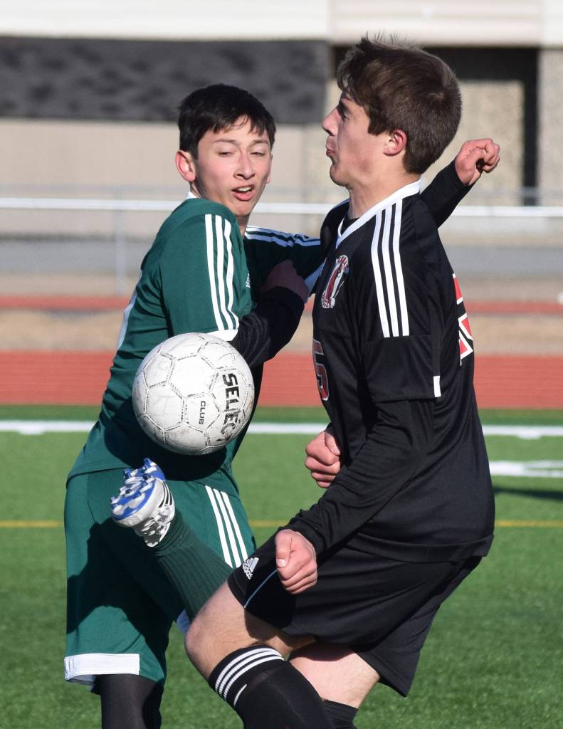 Sewards John Moriarty (left) attempts to keep the ball from Kenais Tucker Vann Tuesday in a conference clash at Kenai Central High School. (Photo by Joey Klecka/Peninsula Clarion)