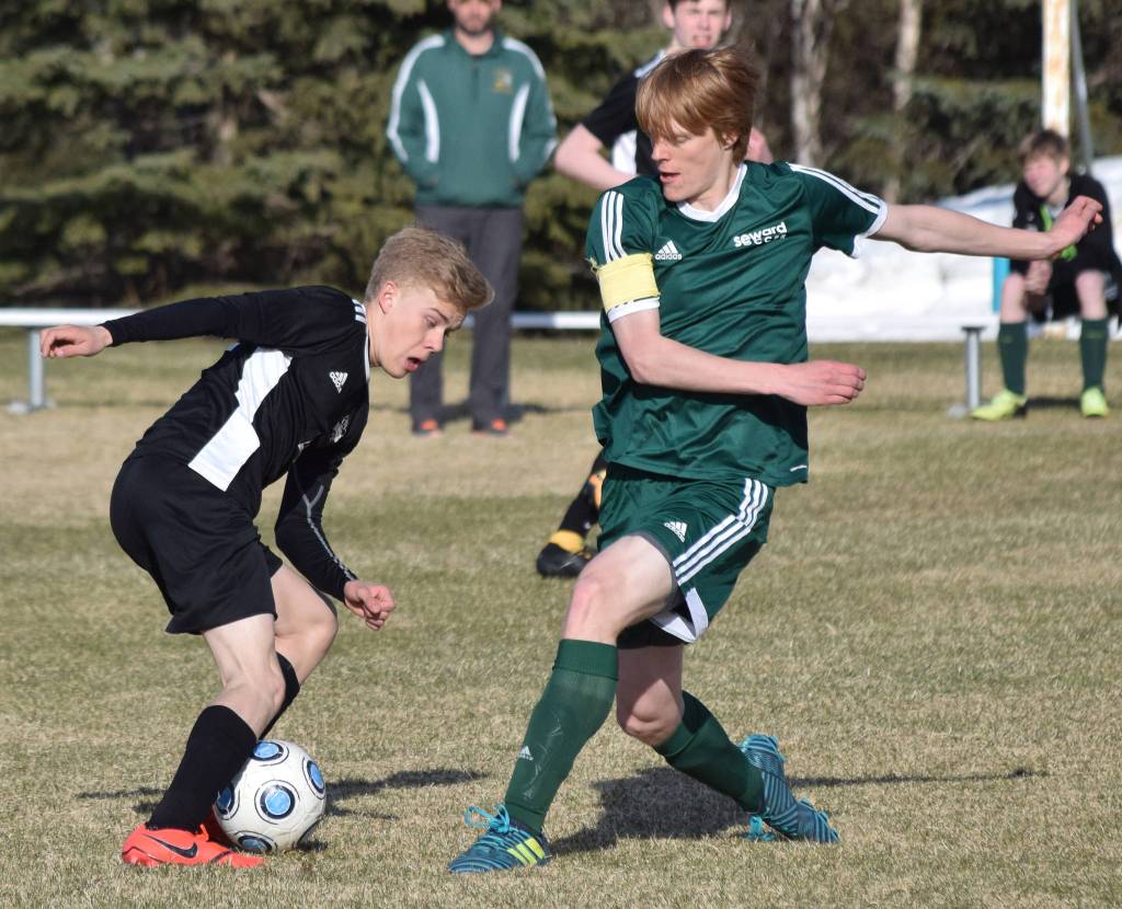 Nikiskis Gavin White (left) battles against Sewards Max Pfeiffenberger Friday afternoon in a Peninsula Conference contest at Nikiski High School. (Photo by Joey Klecka/Peninsula Clarion)