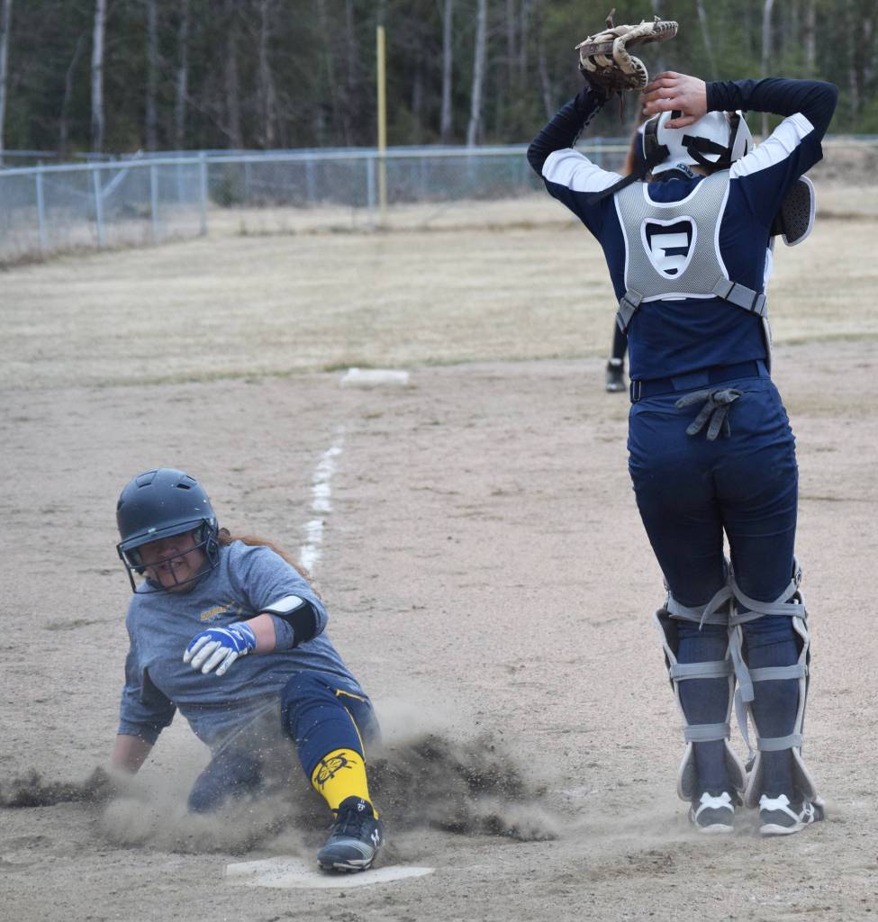 Homers Brianna Hetrick slides home behind Soldotna catcher Casey Card Tuesday evening in a Northern Lights Conference game in Soldotna. (Photo by Joey Klecka/Peninsula Clarion)