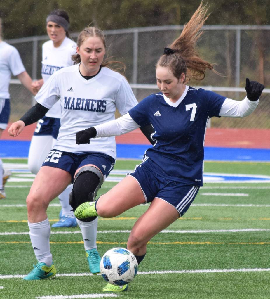 Soldotnas Journey Miller (7) unleashes a kick in front of Homers Brenna McCarron Saturday, May 11, 2019, in a Peninsula Conference game in Soldotna, Alaska. (Photo by Joey Klecka/Peninsula Clarion)