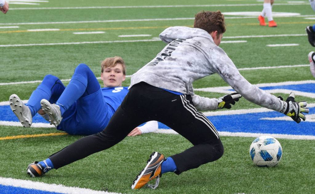 Soldotnas Rory Nelson watches as SoHi goalkeeper Colton Sorhus (forwar) falls on the ball Saturday, May 11, 2019, against Homer in a Peninsula Conference game in Soldotna, Alaska. (Photo by Joey Klecka/Peninsula Clarion)