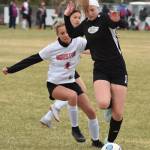 Nikiskis Lillian Carstens dribbles the ball with Houstons Megan Davies behind her Friday, May 10, 2019, in a nonconference game in Nikiski, Alaska. (Photo by Joey Klecka/Peninsula Clarion)