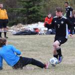 Nikiskis Justin Harris (7) challenges Houston goaltender Niko Wilkenson for the ball Friday, May 10, 2019, in a nonconference game in Nikiski, Alaska. (Photo by Joey Klecka/Peninsula Clarion)