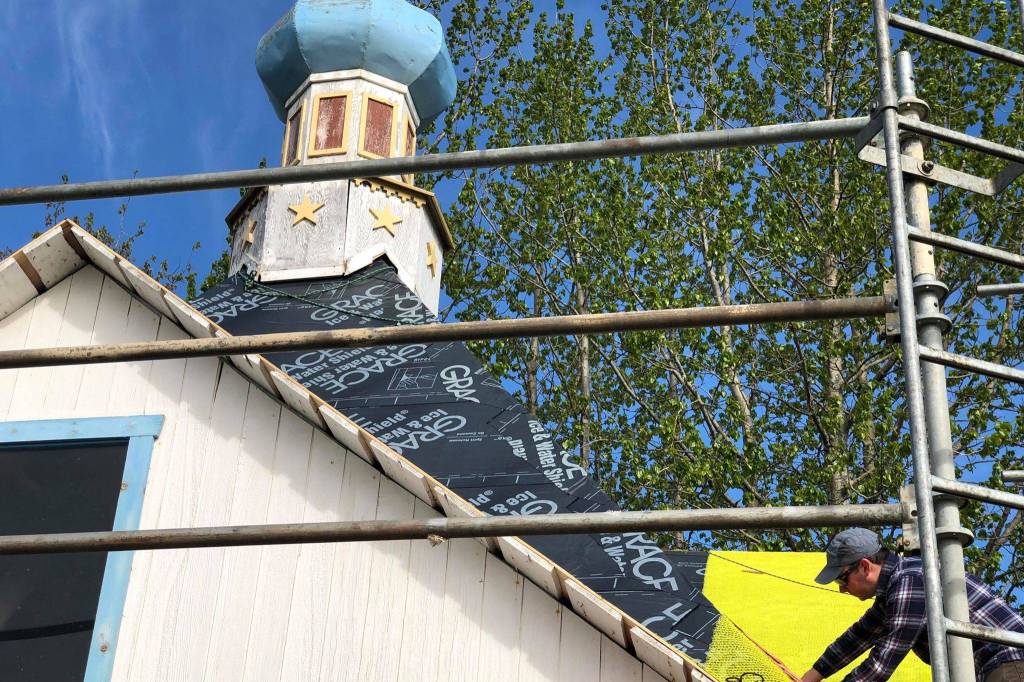 John Wachtel, a former National Parks Service employee, places new cedar shingles on the roof of the Saint Nicholas Memorial Chapel as part of new restorative efforts, on Tuesday, May 21, 2019, in Old Town Kenai, Alaska. (Photo by Victoria Petersen/Peninsula Clarion)