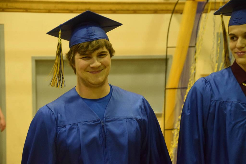 Jordan Buerge, left, and James Strianese, right, walk to their seats during the Kenai Alternative High School 2019 graduation in Kenai, Alaska on May 22, 2019. (Photo by Brian Mazurek/Peninsula Clarion)