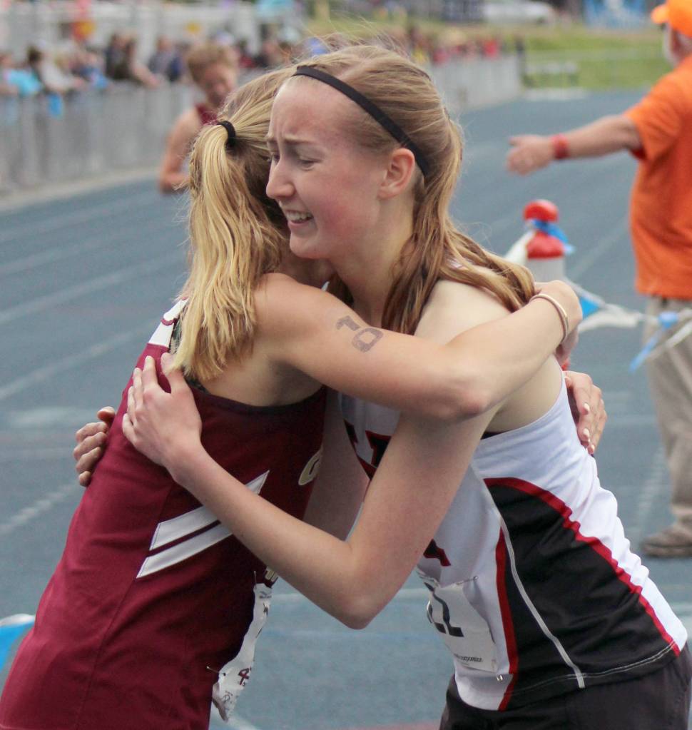 Kenai Centrals Jaycie Calvert hugs competitor Mazzy Jackson of Grace Christian on Saturday at Palmer High School at the state track and field meet. (Photo by Tim Rockey/Frontiersman)