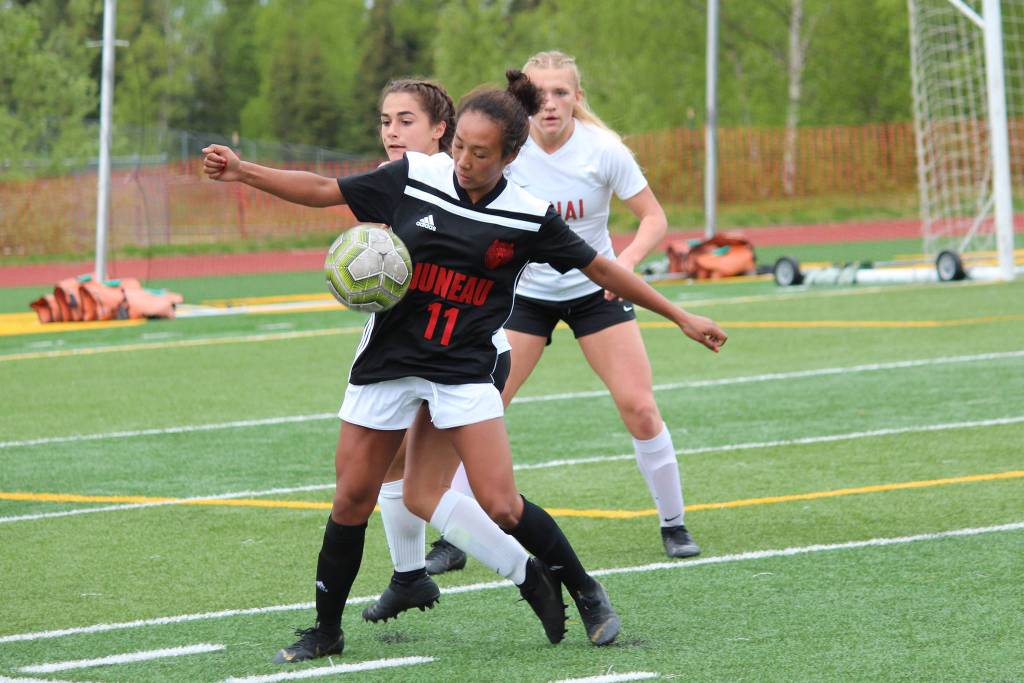 Juneaus Malia Miller grounds the ball under pressure from Kenai Central players in a Friday, May 24, 2019 semifinal game during the Division II state soccer championships at Service High School in Anchorage, Alaska. (Photo by Megan Pacer/Homer News)