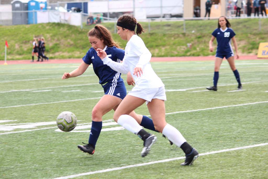 Soldotnas Katherine Bramante and Thunder Mountains Keana Villanueva race to the ball during a semifinal game at the Division II state soccer championships Friday at Service High School in Anchorage. (Photo by Megan Pacer/Homer News)