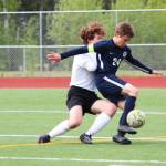 Homers Austin Shafford battles to control the ball while under pressure from Grace Christians Jackson Tanner during a Friday, May 24, 2019 game in the Division II state soccer championship tournament at Eagle River High School in Eagle River, Alaska. (Photo by Megan Pacer/Homer News)