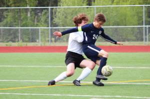 Homers Austin Shafford battles to control the ball while under pressure from Grace Christians Jackson Tanner during a Friday, May 24, 2019 game in the Division II state soccer championship tournament at Eagle River High School in Eagle River, Alaska. (Photo by Megan Pacer/Homer News)