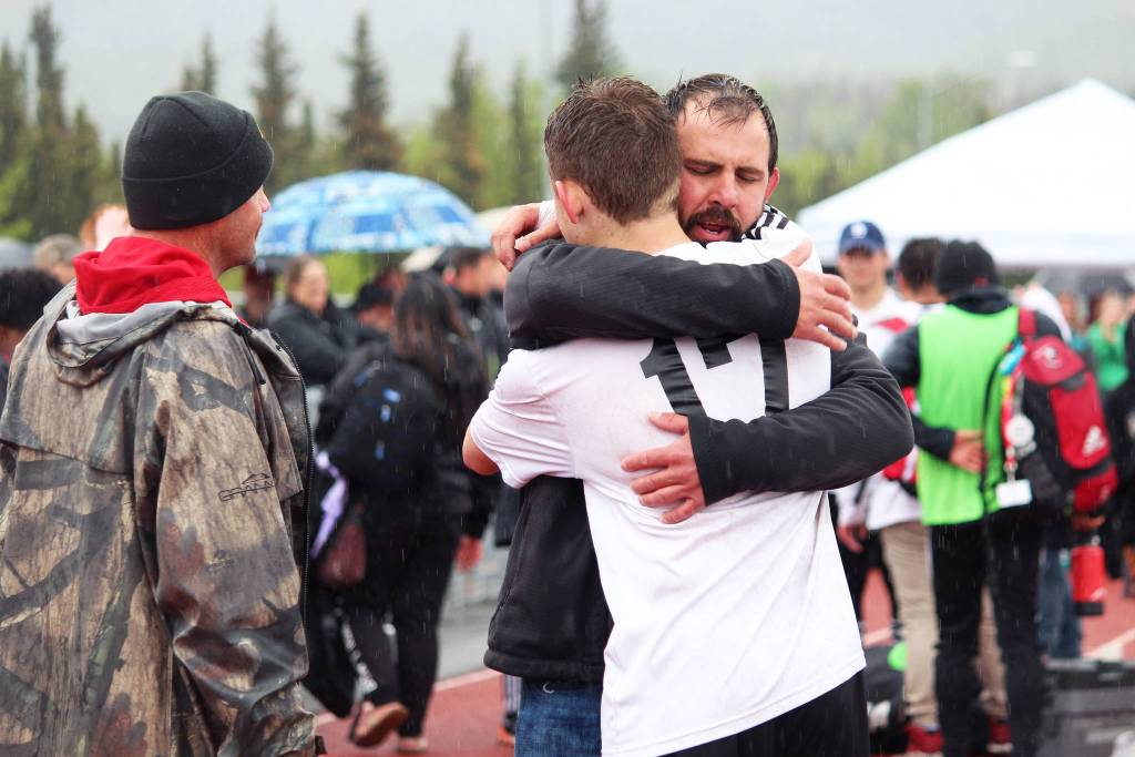 Kenai boys soccer team head coach Shane Lopez hugs player Travis Verkuilen as they celebrate their win over Juneau in the Saturday final game of the Division II state soccer championships at Service High School in Anchorage. (Photo by Megan Pacer/Homer News)