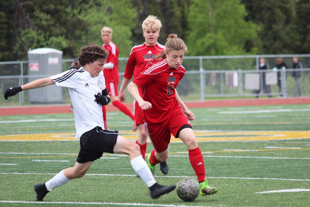 Kenais Damien Redder (left) fights for the ball with Juneaus Jackson Norberg during the championship game of the Division II state soccer tournament Saturday at Service High School in Anchorage. (Photo by Megan Pacer/Homer News)
