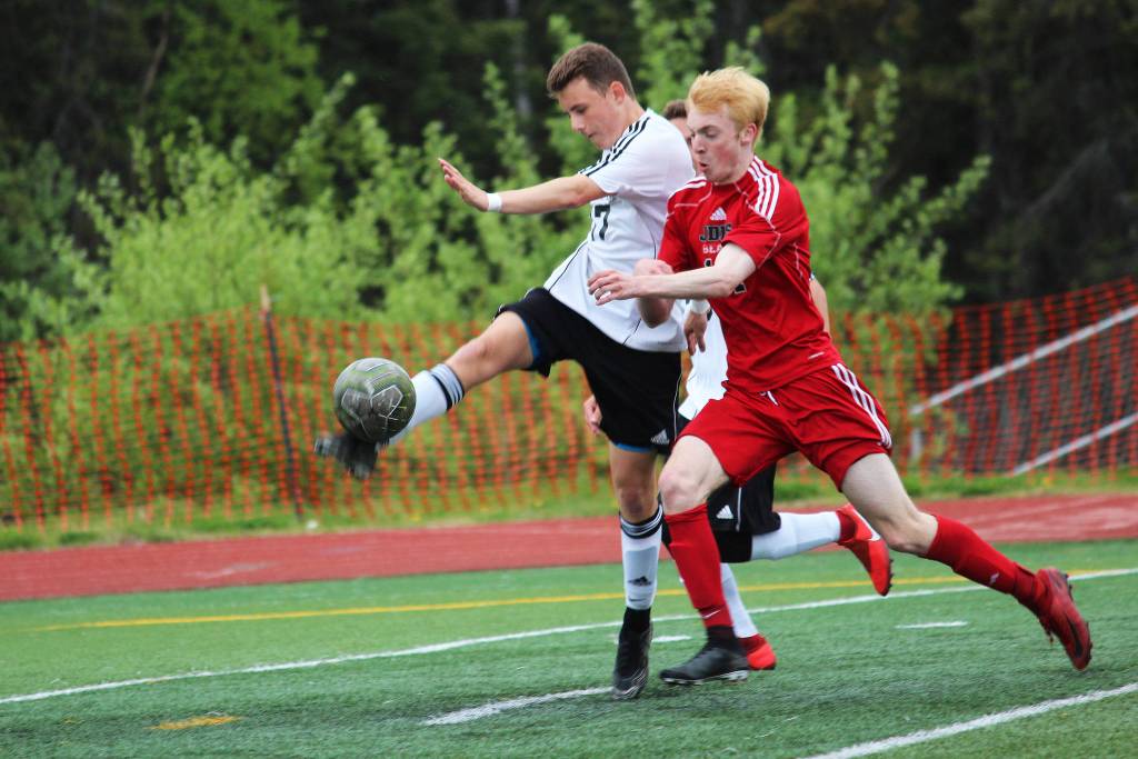 Kenai defender Travis Verkuilen clears the ball while under pressure from Juneaus Kannon Goetz during the champioship match of the Division II state soccer tournament Saturday, May 25, 2019 at Service High School in Anchorage, Alaska. (Photo by Megan Pacer/Homer News)