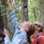 Sasha Brott, left, and her mom Olga, right, attempt to identify a tree without looking during a guided hike on Centennial Trail in the Kenai National Wildlife Refuge on June 1, 2019. (Photo by Brian Mazurek/Peninsula Clarion)