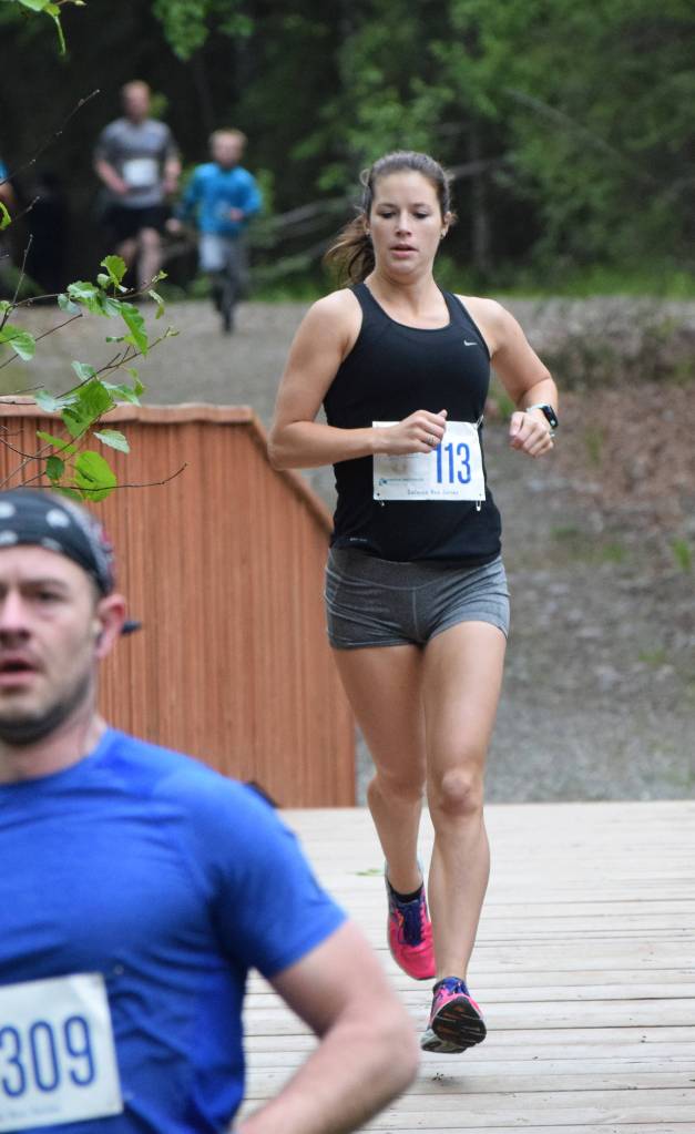 Womens 5K winner Riley Burroughs races over a bridge early Saturday, June 8, 2019, at the Run for the River 5-kilometer/10-mile races in Soldotna, Alaska. (Photo by Joey Klecka/Peninsula Clarion)