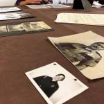 Old photographs of members of the Kenai Volunteer Fire Department lay on a table Thursday, June 6, 2019, during the opening reception to the June exhibit Historic Buildings of Kenai. (Photo by Joey Klecka/Peninsula Clarion)
