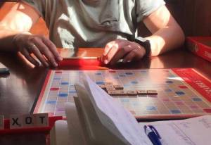Hallie Bergwall makes a move in a Scrabble game on Thursday at Resurrect Art Coffee House in Seward, Alaska. Bergwall took home the win. (Photo by Kat Sorensen/Peninsula Clarion)