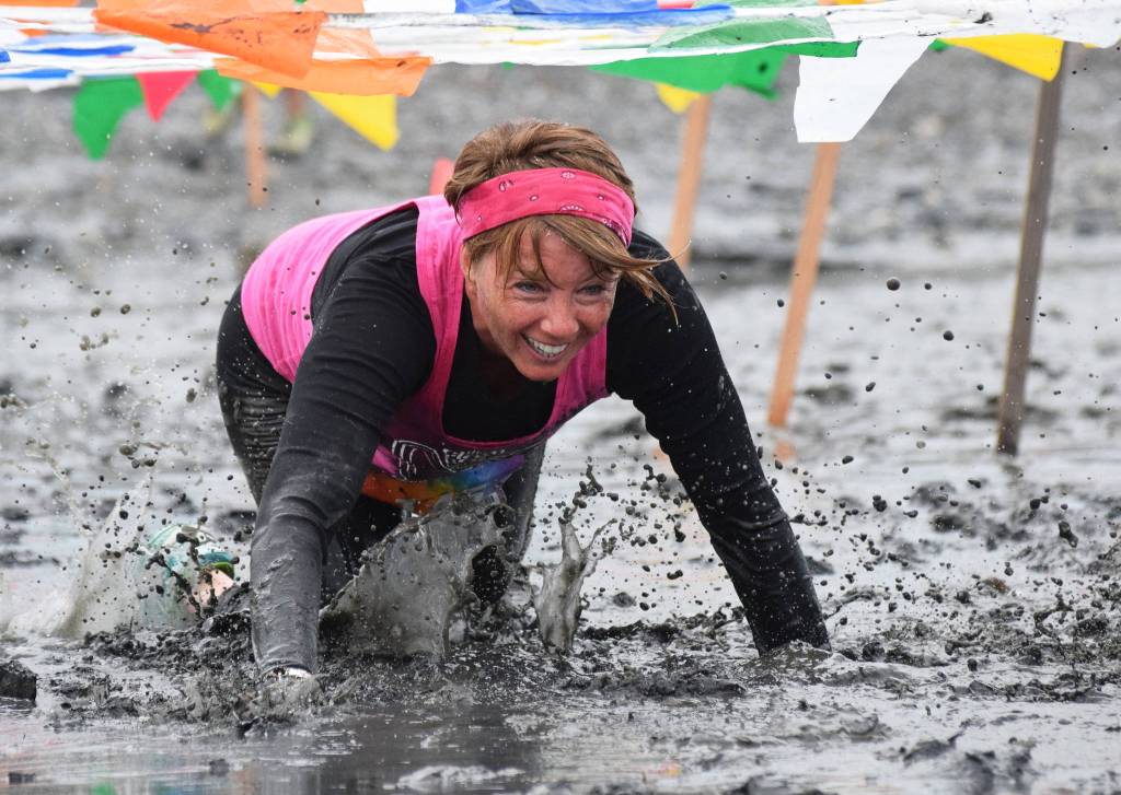 Jess Gutzwiler crawls through the mud Saturday at the Ninilchik Clam Scramble Mud and Obstacle Run in Ninilchik. (Photo by Joey Klecka/Peninsula Clarion)