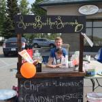 Brothers Gunnar Lervig, back, and Ryder Lervig, front, smile for the camera at their lemonade stand outside First American Title during Lemonade Day in Soldotna, Alaska on June 29, 2019. (Photo by Brian Mazurek/Peninsula Clarion)