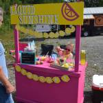 Ava McCaughey serves a customer at her lemonade stand on Binkley Street during Lemonade Day in Soldotna, Alaska on June 29, 2019. (Photo by Brian Mazurek/Peninsula Clarion)