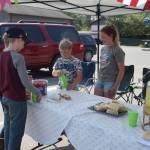 Nathan and Avery Powell, right, serve customers at their lemonade stand in outside of Kenai Kids Therapy during Lemonade Day in Soldotna, Alaska on June 29, 2019. (Photo by Brian Mazurek/Peninsula Clarion)